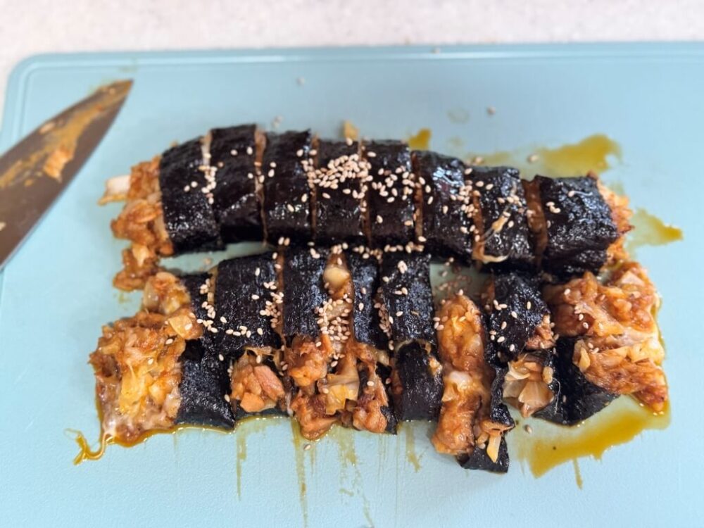 キンパブを食べやすい大きさに切った姿で、一列は形を保ち、一列は側面が破裂している。