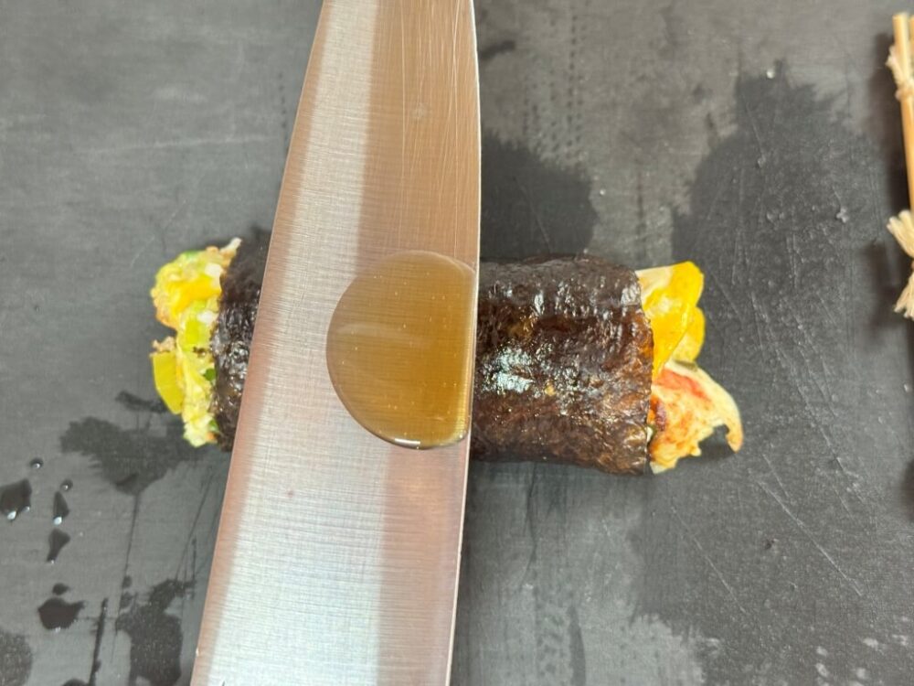 Aceite de sésamo en el lado del cuchillo para cubrir el kimbap