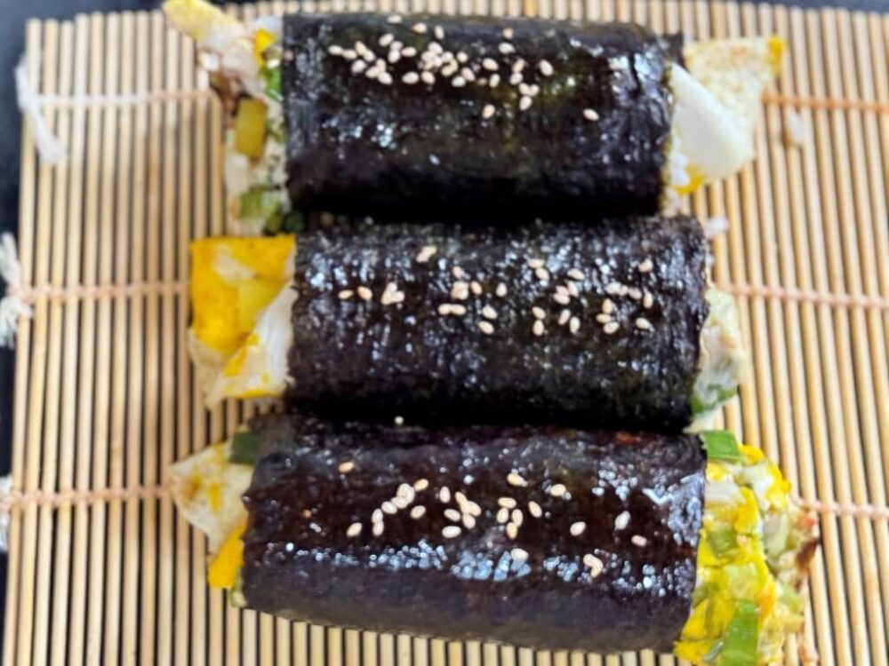 Kimbap recubierto con aceite de sésamo y espolvoreado con semillas de sésamo.