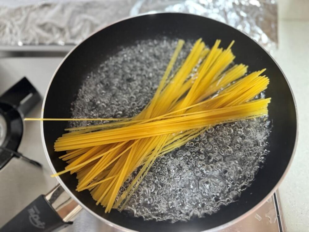 沸騰したお湯にパスタを入れる様子