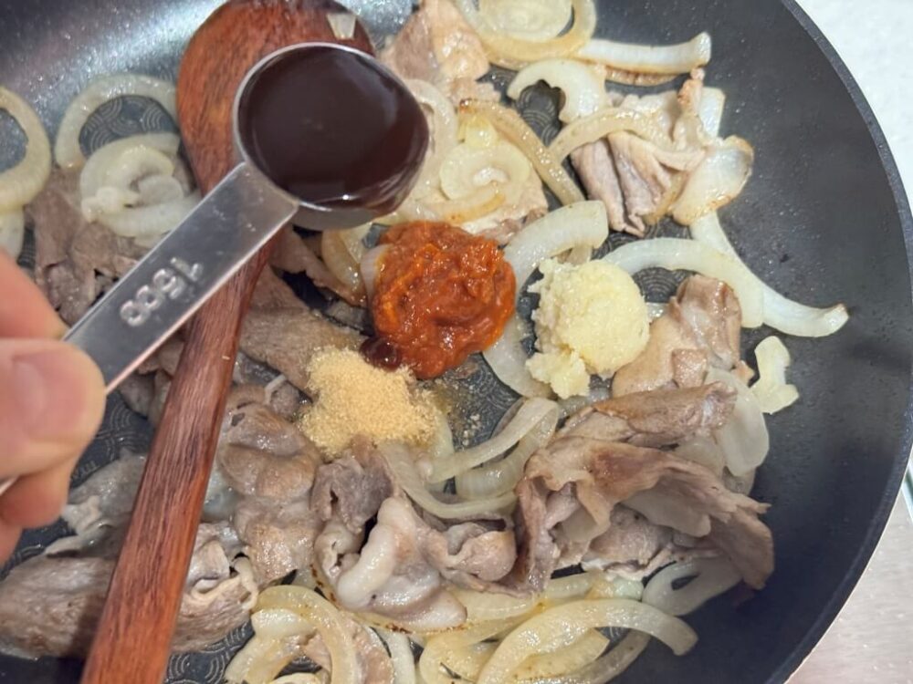 サムジャン、砂糖、みじん切りニンニク、トンカツソースを入れる様子