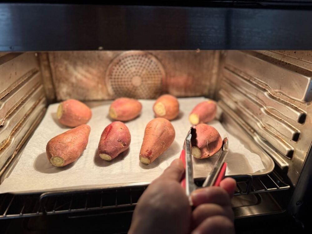 Flipping a sweet potato that has been baking for an hour.