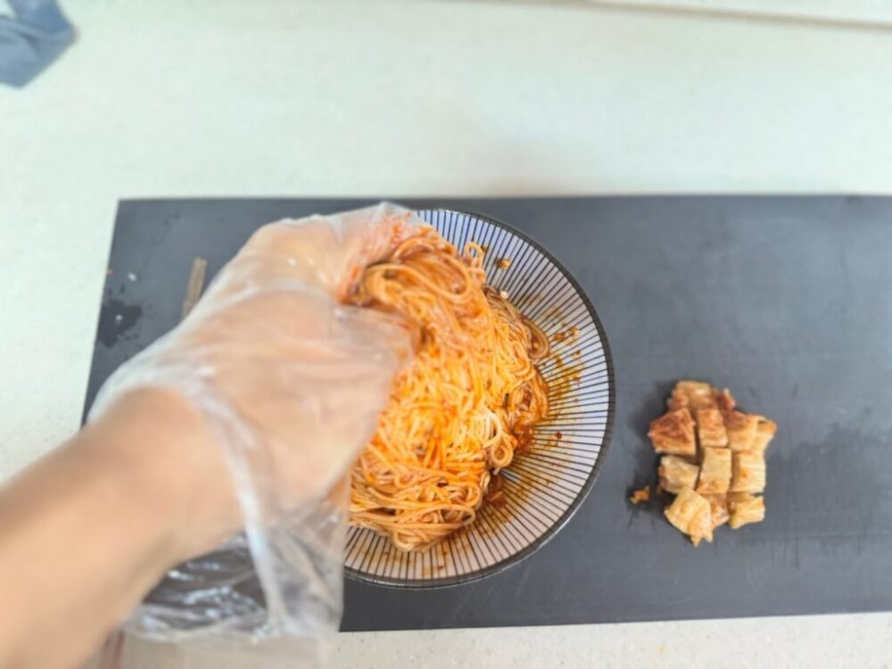 素麺をタレに混ぜて和える過程の写真