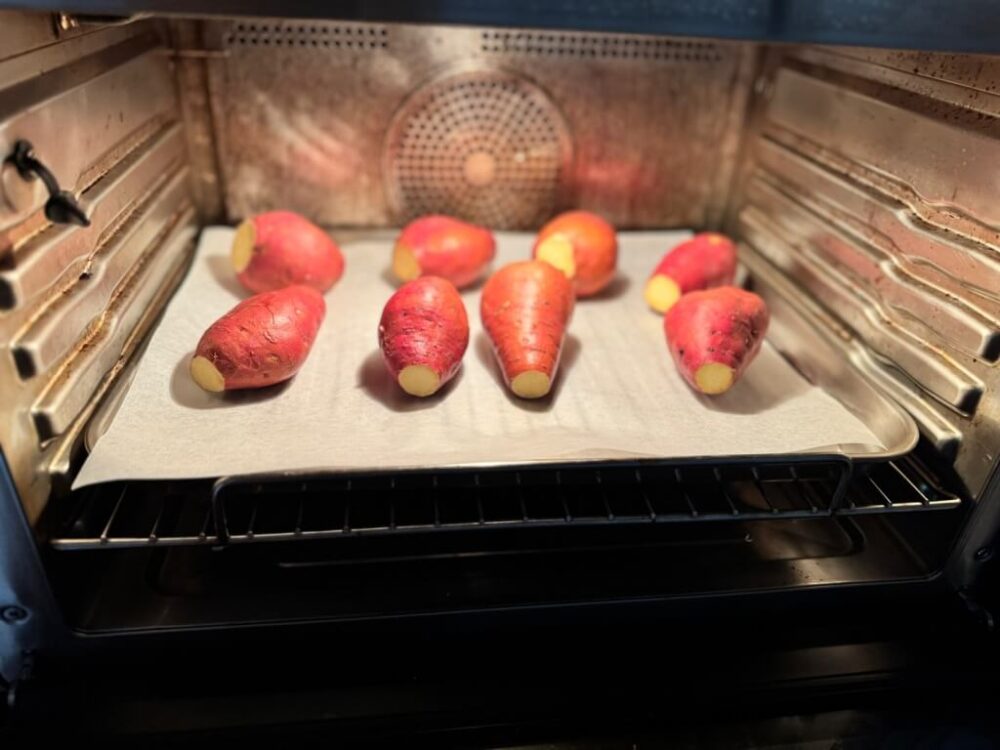 Sweet potatoes placed on paper foil and placed in the air fryer.