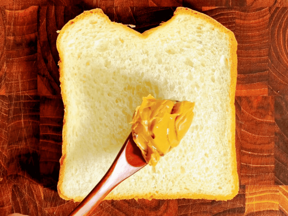 Spreading peanut butter on bread