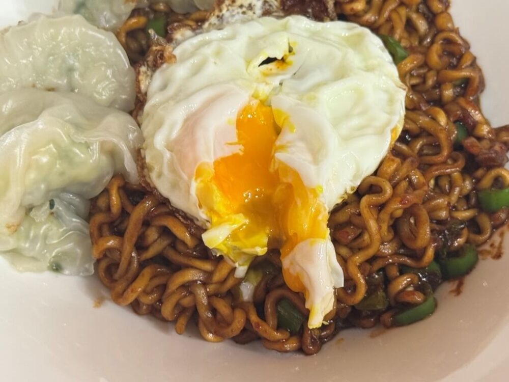 Yoon Namno finishes her spaghetti recipe and tops it with a poached egg.