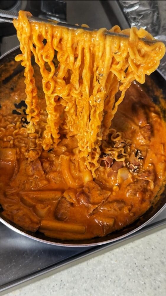 Perfecting the rosé buldak tteokbokki recipe and lifting the ramen noodles into the air.
