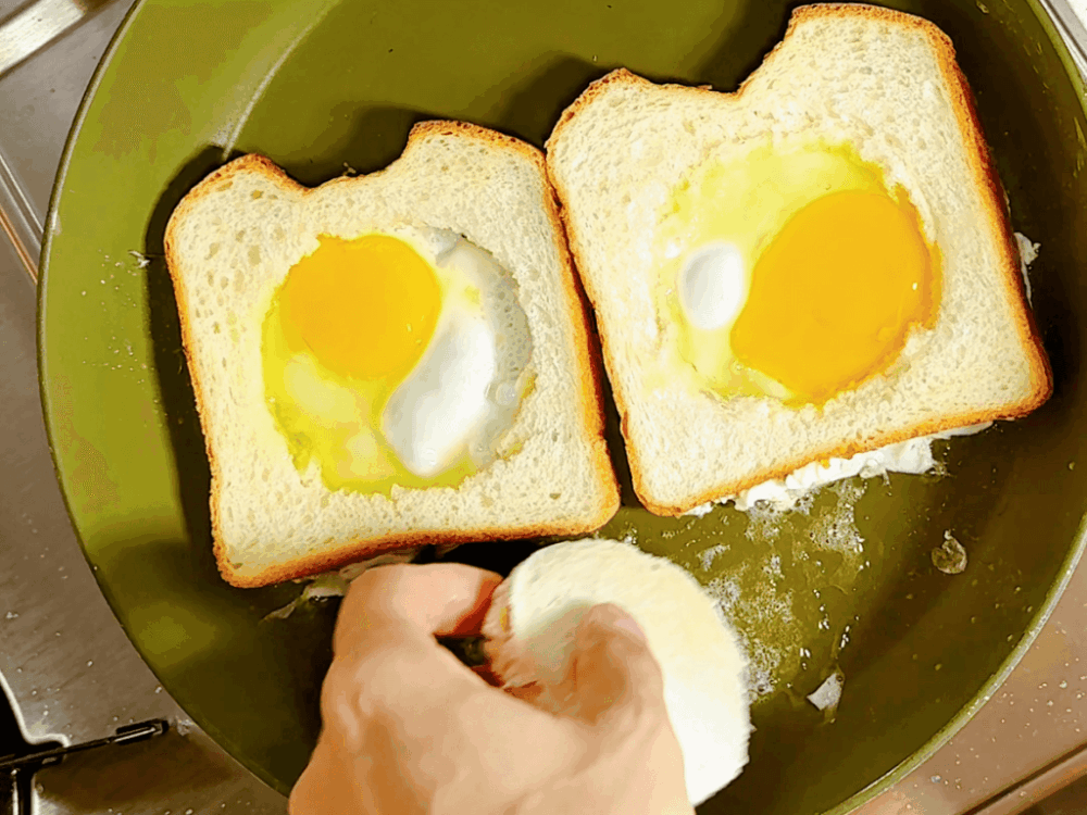 Crack an egg into the hole of the bread and place it in the center of the pressed bread.