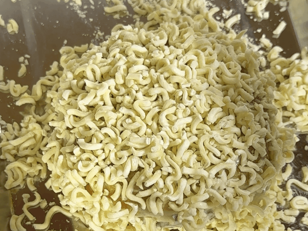 Fideos ramen desmenuzados pegados a una hamburguesa