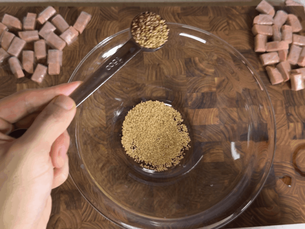 Adding whole sesame seeds to a bowl