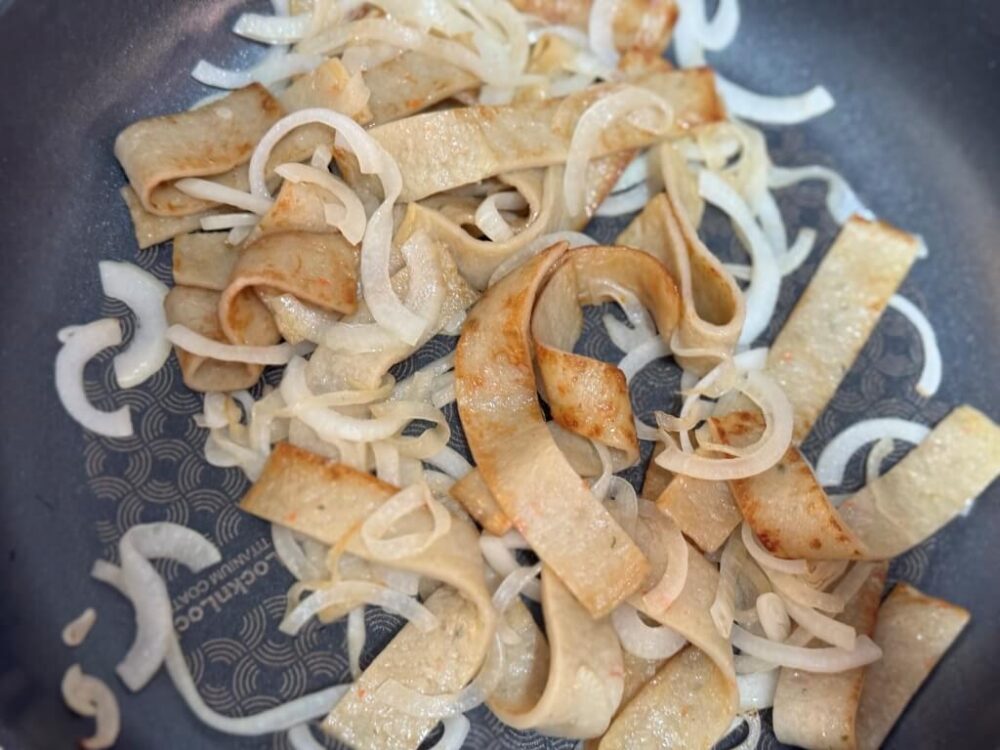 Freír los pasteles de pescado y las cebollas hasta que estén dorados