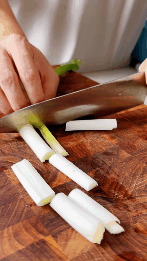 Halving a green onion and cutting it into finger-sized pieces
