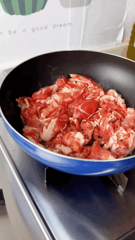 The marinated pork is placed in the pan.